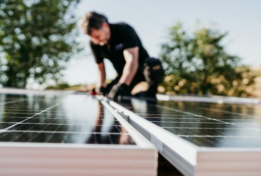 technician man assembling solar panels on house roof for self consumption energy